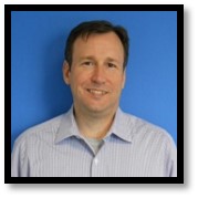 David Edge headshot with a bright blue background. 
